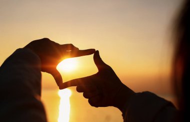 Planlama ve vizyon, Kadın Elleri çerçeve arıyor gün batımında odaklan.