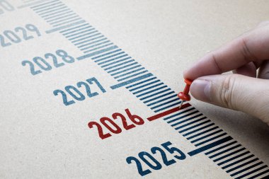 Kahverengi kağıtta kırmızı pim işaretleri 2026. Yeni yıl konseptine başlayın, 2025 'ten 2026' ya geçişin yanı sıra hayatta başarı için yeni hedefler belirleyin.