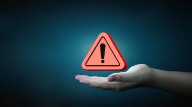 Tehlike ve hata alarmı konsepti. İnsan eliyle kırmızı üçgen uyarı sembolü. Güvenlik sistemlerinin bakımı ve hassas veri koruması.