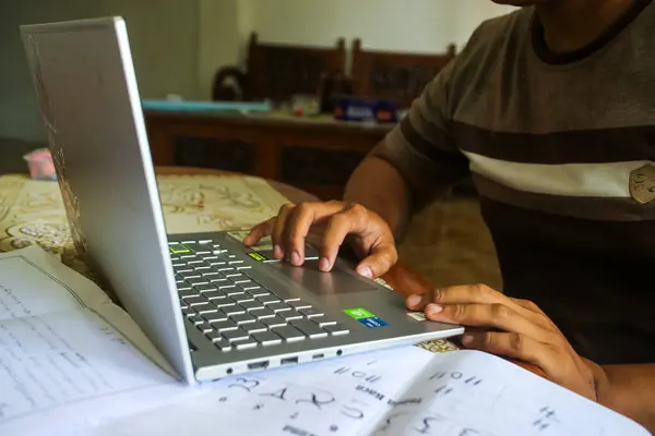 stock image Kediri, Indonesia. 31-5-2024: Laptop and someone's hand on the desk for work, internet and connection. Business, corporate and secretary or receptionist typing on laptop computer for online admin.