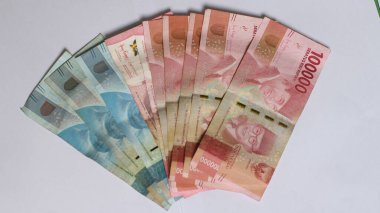 Surabaya, Endonezya. 01-10-2025: Banknotlar, Endonezya Cumhuriyeti 'nin resmi parası. 100.000 rupianın nominal değeri. İzole edilmiş beyaz arkaplan ile paranın yakın plan fotoğrafı.