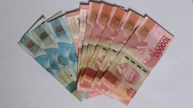 Surabaya, Endonezya. 01-10-2025: Banknotlar, Endonezya Cumhuriyeti 'nin resmi parası. 100.000 rupianın nominal değeri. İzole edilmiş beyaz arkaplan ile paranın yakın plan fotoğrafı.