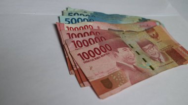 Surabaya, Endonezya. 01-10-2025: Banknotlar, Endonezya Cumhuriyeti 'nin resmi parası. 100.000 rupianın nominal değeri. İzole edilmiş beyaz arkaplan ile paranın yakın plan fotoğrafı.