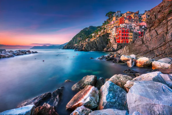 Günbatımında renkli evler Cinque Terre, İtalya 'daki Riomaggiore kasabasında bir kayanın üzerinde.