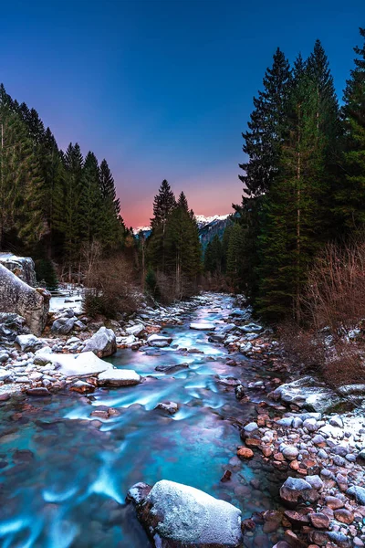 Nardis Şelalesi kışın gün batımında dağlarda Trento, Val di Genova, İtalya. Dolomitlerin güzel kış manzarası.