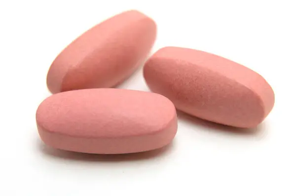 Beyaz arkaplanda izole edilmiş çeşitli B vitamini hapları makro