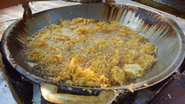 Bir sokak satıcısının tavada kızartma sürecinde sebzeli bakwan..