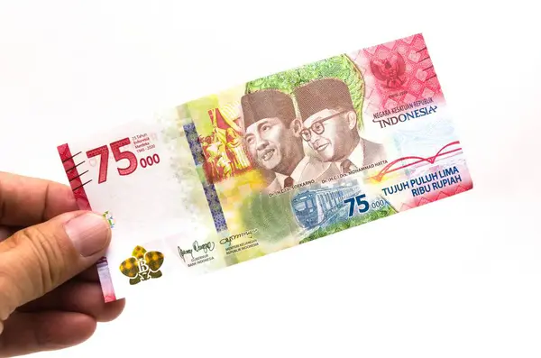 IDR Endonezya Rupiah Endonezya 'nın resmi para birimidir. Ödeme yapmak için Asyalı bir adamın eli bir parça para tutuyor. İş Geliri Yatırım Ekonomisi ve Finans Para Konsepti 75.000 Rupiah.