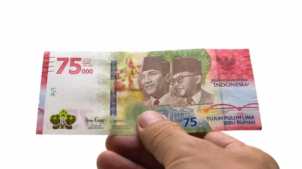 IDR Endonezya Rupiah Endonezya 'nın resmi para birimidir. Ödeme yapmak için Asyalı bir adamın eli bir parça para tutuyor. İş Geliri Yatırım Ekonomisi ve Finans Para Konsepti 75.000 Rupiah.