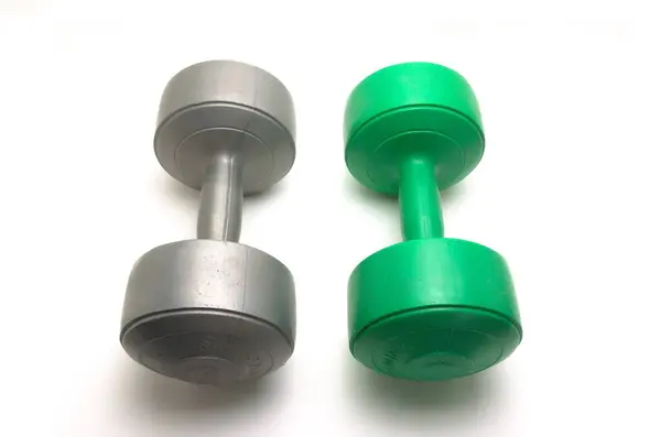 Beyaz arka planda iki adet gri ve yeşil halterli 5 kiloluk halter.