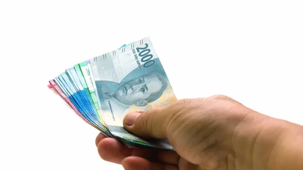IDR Endonezya Rupiah Endonezya 'nın resmi para birimidir. Ödeme yapmak için Asyalı bir adamın eli biraz para tutuyor. Ekonomik Kavram Yatırım Girişimi ve Para Finansmanı.