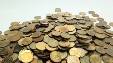 A man's hand takes coin from a pile of coins on the table. Coins with a denomination of 500 rupiah.