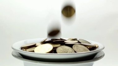 A man's hand takes coin from a pile of coins on the table. Coins with a denomination of 500 rupiah.