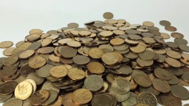 A man's hand takes coin from a pile of coins on the table. Coins with a denomination of 500 rupiah.