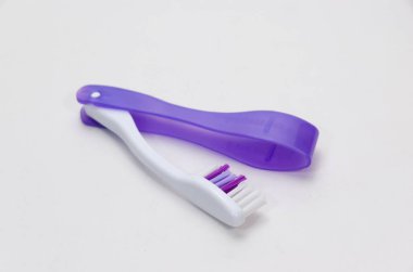 Katlanan diş fırçası beyaz arkaplanda izole edilmiş. Katlanan diş fırçaları seyahat ederken çok kullanışlıdır. Yumuşak ışık, stüdyo çekimi, açı görünümü