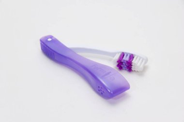 Katlanan diş fırçası beyaz arkaplanda izole edilmiş. Katlanan diş fırçaları seyahat ederken çok kullanışlıdır. Yumuşak ışık, stüdyo çekimi, açı görünümü