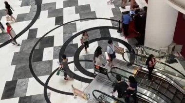 Jakarta, Endonezya - 11 Mart 2024; Lippo Mall Puri alışveriş merkezinde yürüyen merdiven kullanan insanlar.
