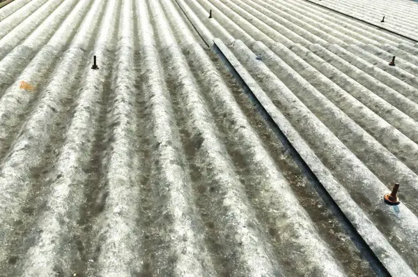 Asbeston 'dan yapılmış eski bir örneğin gri bir çatı parçası.