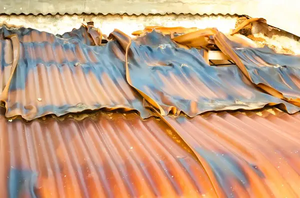 Eski ve terk edilmiş bir evin hasarlı plastik çatısı.