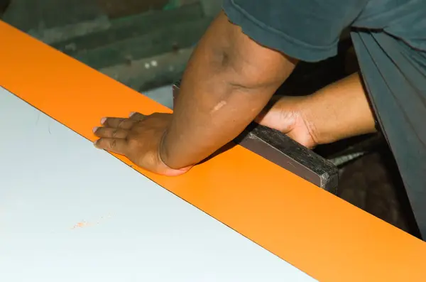 Bir marangozun ahşap talaşı kullanarak ahşap bir dolabın yapımını düzenlerken çekilmiş fotoğrafı..