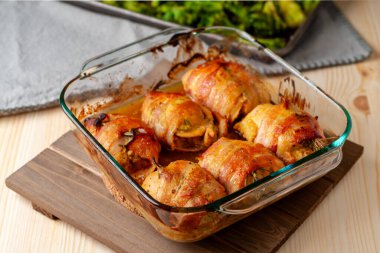 Domuz pastırmasına sarılı kızarmış tavuk ve cam güveç.