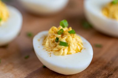 Pirzola ile süslenmiş bir kesme tahtasının üzerindeki baharatlı yumurtaların yakın plan görüntüsü