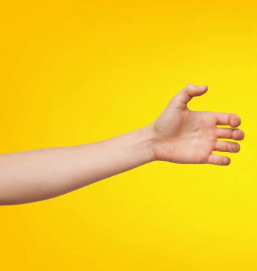 Kadın eli sarı arka planda izole edilmiş. Parmaklarıyla el hareketi yapan bir kadın..