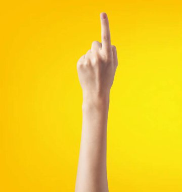Fotokopi alanı olan sarı bir arkaplanda orta parmağı gösteren bir kadın eli