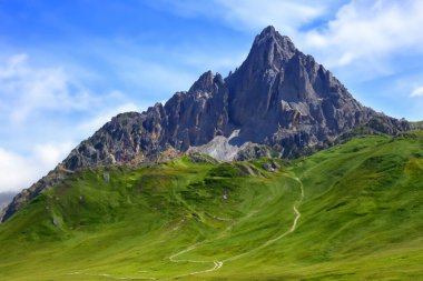 Yeşil çimenli ve mavi gökyüzü olan dağ manzarası. Dolomitler, İtalya