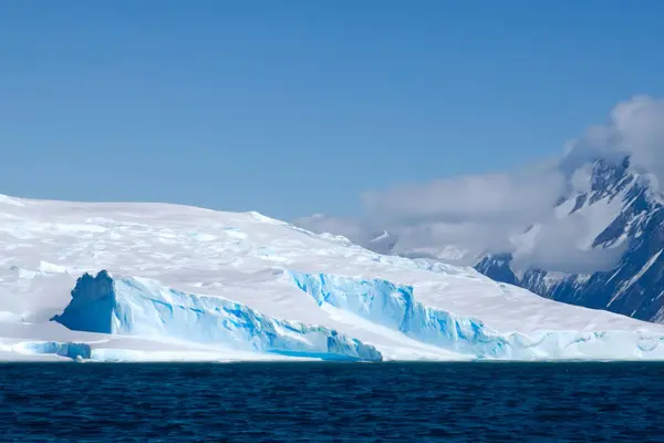 氷山が海に溶け込む南極大陸の氷は その素晴らしく美しい自然現象で広く認識されています ロイヤリティフリーのストック写真