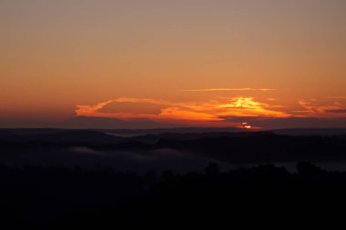 Gün batımında güneş ışınlarıyla dağlarda otlaklar.