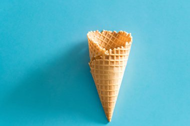 Dondurma külahı mavi arka planda. Minimum yaz konsepti. Düz yatış, üst görünüm.