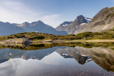 Dağlar bir dağ gölünün suyuna yansıyor. Norveç.