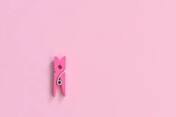 stock image pink clothespin lying flat on pink background