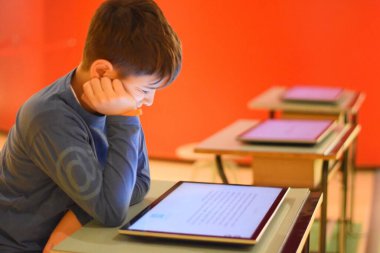 Okulda dijital tablet kullanan genç çocuk