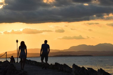 Gün batımında sahilde insan silueti.