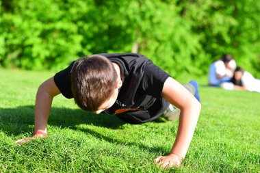 Parkta oynayan genç çocuk.