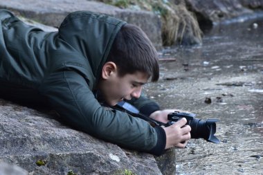 Ormanda kameralı bir çocuk.