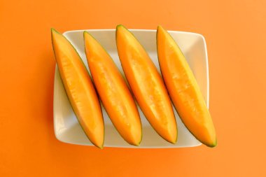 Olgun taze olgun portakal dilimlerini sarı bir tabakta kes, üst manzara, düz uzan 