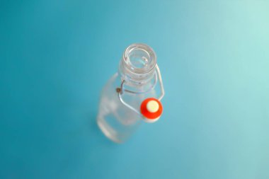 Mavi arka planda yukarıdan görünen şişe