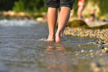 Çocuk denizde yürüyor. Seçici odaklanma. Doğa.
