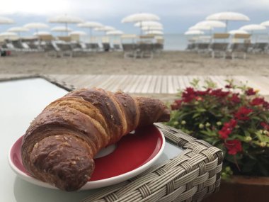 Plaj barındaki masada kruvasan yakın plan.