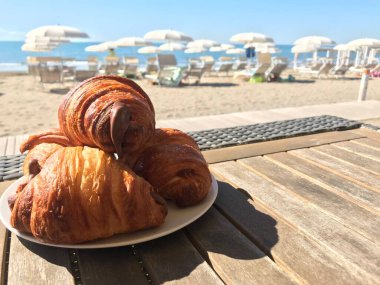 Plaj bar masasında kruvasanlar