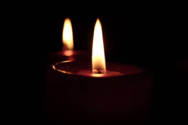 Karanlık arka planda mum yakmak.  