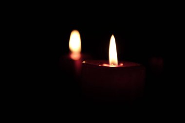 Karanlık arka planda mum yakmak.  