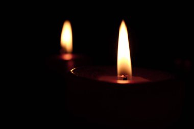 Karanlık arka planda mum yakmak.  