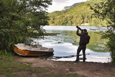Adam gölde fotoğraf avcılığı yapıyor.