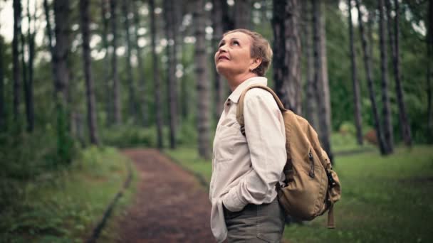 一位头戴背包的高个子高加索女人在公园里散步时享受新鲜空气 — 图库视频影像