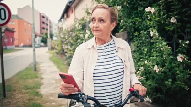 Potret Seorang Wanita Senior Kaukasia Menggunakan Smartphone Nya Ketika Berdiri — Stok Video