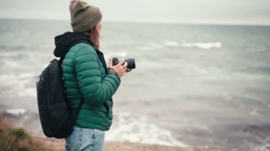 Bir kadın fotoğrafçının seyahat ederken deniz manzarasının fotoğraflarını çektiği yavaş çekim görüntüleri..